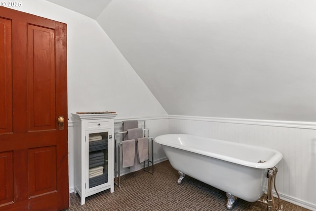 bathroom featuring lofted ceiling and a bath