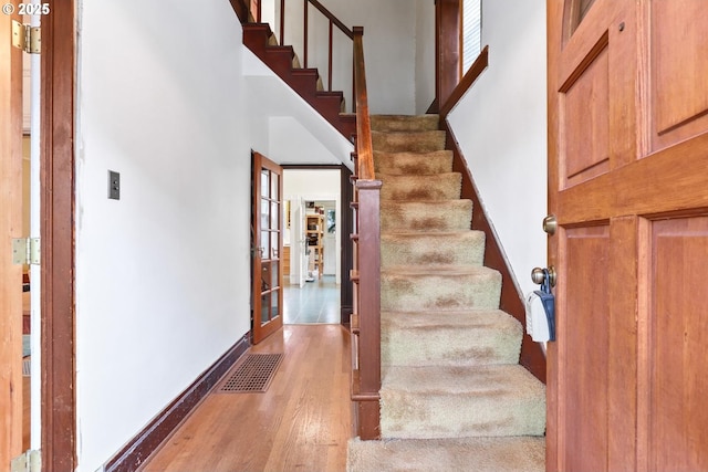 stairs featuring hardwood / wood-style floors