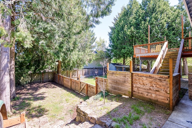 fenced backyard featuring stairs and a deck