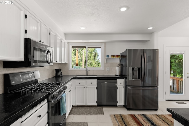 kitchen with stainless steel fridge with ice dispenser, dishwashing machine, gas range oven, a sink, and dark countertops