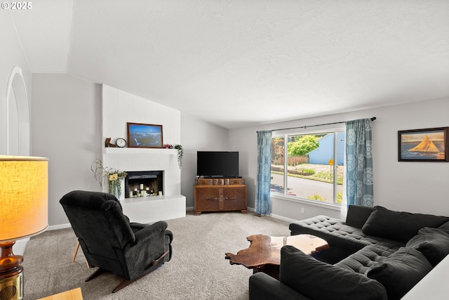 carpeted living area with lofted ceiling, a tiled fireplace, a textured ceiling, and baseboards