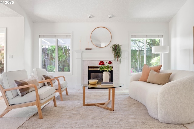 living area featuring plenty of natural light, a tile fireplace, and carpet