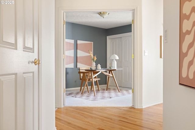 hallway featuring wood finished floors and baseboards