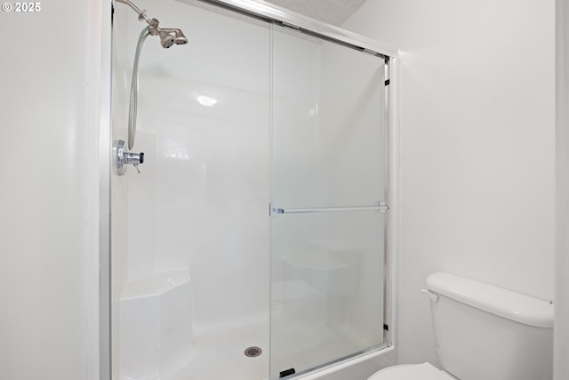 full bath with a stall shower and toilet