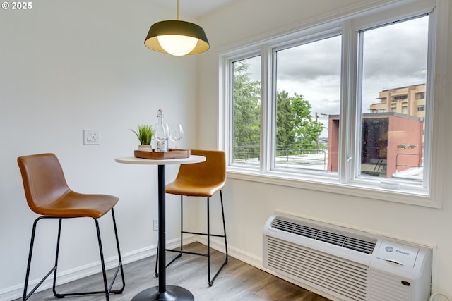 2021 SW Main St Unit 66, Portland, OR 97205 - dining room with wood finished floors, baseboards, and an AC wall unit