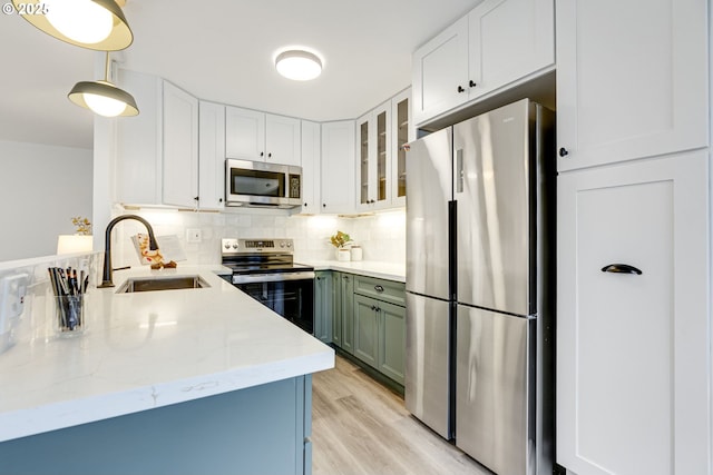 2021 SW Main St Unit 66, Portland, OR 97205 - kitchen with stainless steel appliances, a sink, white cabinets, and tasteful backsplash