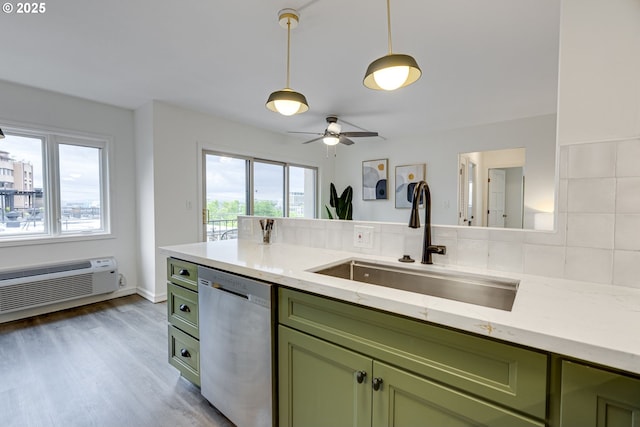 2021 SW Main St Unit 66, Portland, OR 97205 - kitchen with green cabinetry, stainless steel dishwasher, a sink, light wood-type flooring, and light stone counters