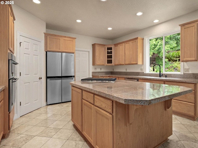 3165 SW Garden View Ave, Portland, OR 97225 - kitchen with stainless steel appliances, a kitchen island, recessed lighting, a sink, and glass insert cabinets