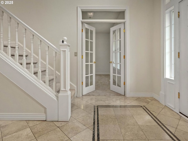 3165 SW Garden View Ave, Portland, OR 97225 - foyer with french doors, baseboards, inlaid floor details, and stairway