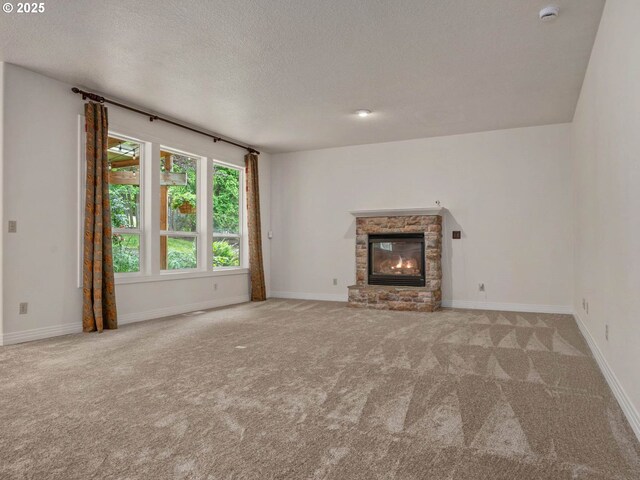 3165 SW Garden View Ave, Portland, OR 97225 - unfurnished living room featuring carpet floors, a stone fireplace, a textured ceiling, and baseboards