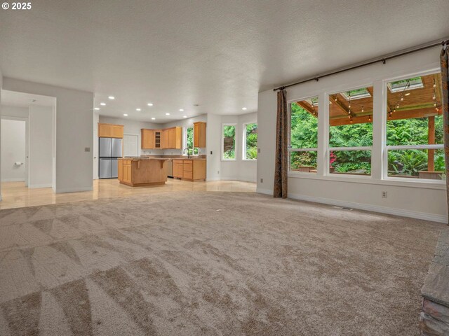 3165 SW Garden View Ave, Portland, OR 97225 - unfurnished living room featuring light colored carpet, baseboards, recessed lighting, a sink, and a textured ceiling