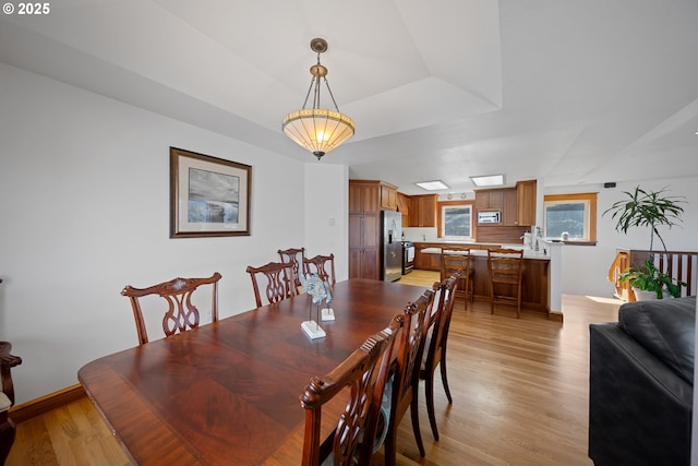 93885 Boulder Pl, Gold Beach, OR 97444 - dining space with baseboards, light wood-style floors, and a tray ceiling