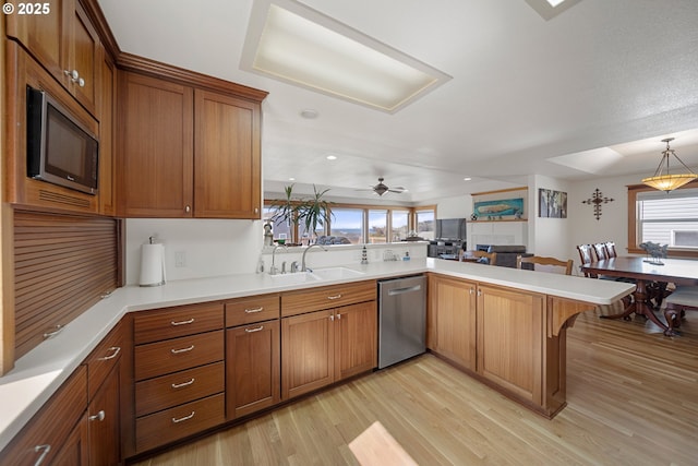 93885 Boulder Pl, Gold Beach, OR 97444 - kitchen with a sink, a peninsula, stainless steel appliances, brown cabinetry, and light wood-style flooring