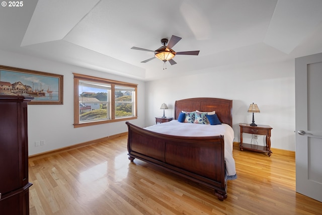 93885 Boulder Pl, Gold Beach, OR 97444 - bedroom featuring a tray ceiling, a ceiling fan, light wood-style flooring, and baseboards