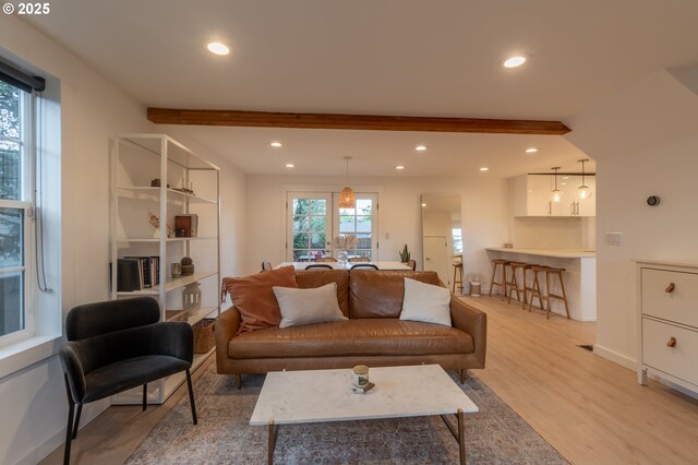 living room featuring light wood-type flooring, recessed lighting, beam ceiling, and baseboards