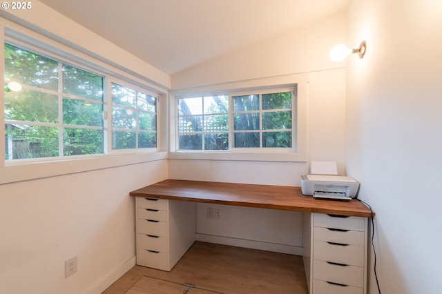 unfurnished office with lofted ceiling and light wood-style flooring