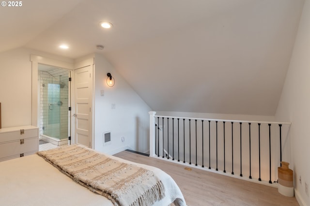 bedroom with vaulted ceiling, light wood-style floors, baseboards, recessed lighting, and ensuite bathroom