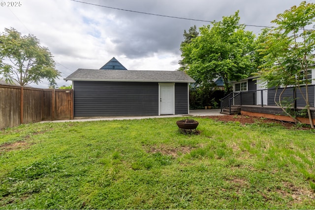 view of yard with an outdoor fire pit, an outbuilding, and a wooden deck