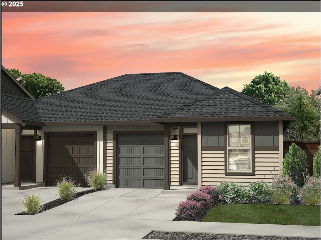 view of front facade with an attached garage, board and batten siding, concrete driveway, and roof with shingles