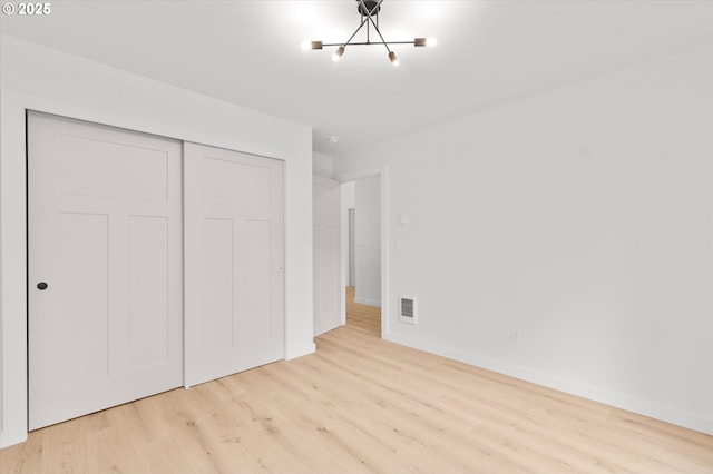 unfurnished bedroom featuring light hardwood / wood-style floors and a closet