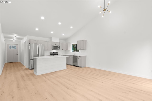 kitchen with a kitchen island, sink, gray cabinetry, a chandelier, and stainless steel appliances