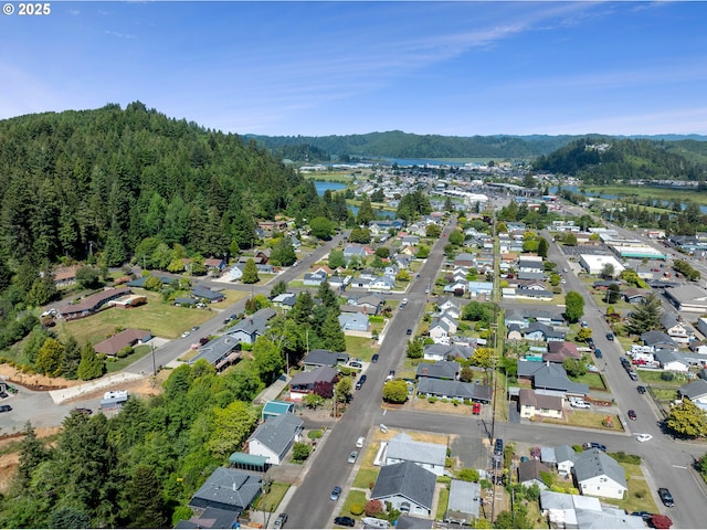 2111 Greenwood Ave, Reedsport, OR 97467 - aerial overview of property's location featuring a large body of water, nearby suburban area, and a forest