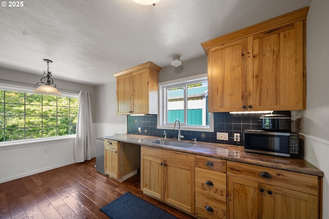 2111 Greenwood Ave, Reedsport, OR 97467 - kitchen featuring stainless steel microwave, a sink, dark wood finished floors, tasteful backsplash, and hanging light fixtures