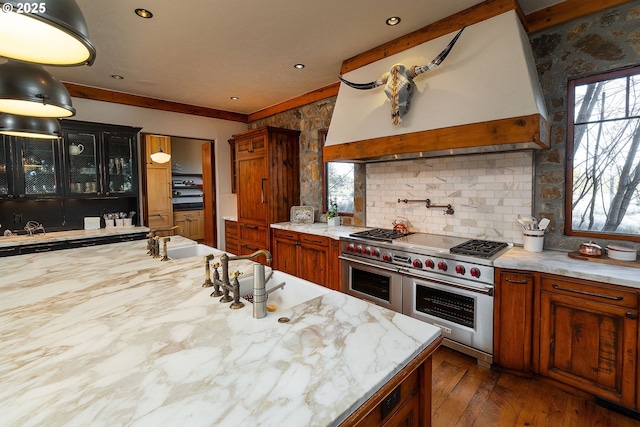 23021 Brushline Ct, Bend, OR 97701 - kitchen featuring double oven range, glass insert cabinets, decorative backsplash, dark wood-style floors, and brown cabinets