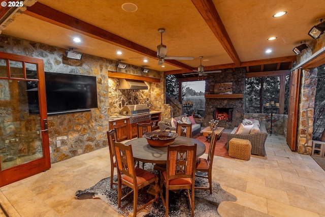23021 Brushline Ct, Bend, OR 97701 - dining area with beamed ceiling, a ceiling fan, recessed lighting, an outdoor stone fireplace, and light stone finish flooring