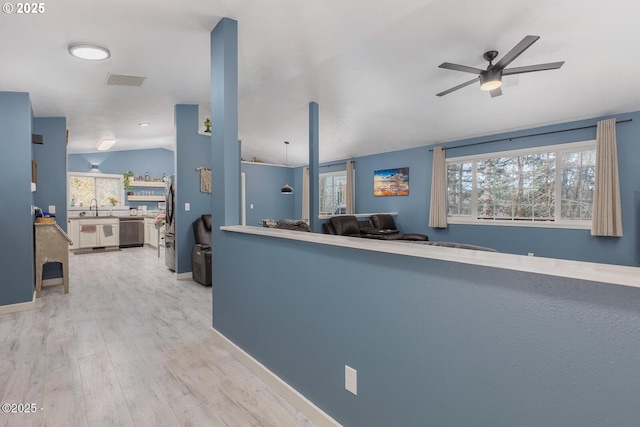 interior space with lofted ceiling, sink, light hardwood / wood-style flooring, plenty of natural light, and stainless steel dishwasher