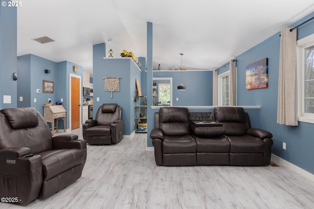 living room with lofted ceiling and light wood-type flooring