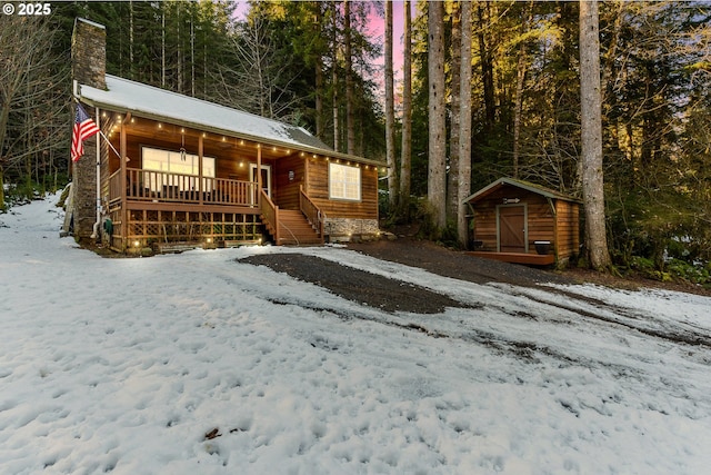 log home with a porch and a storage unit