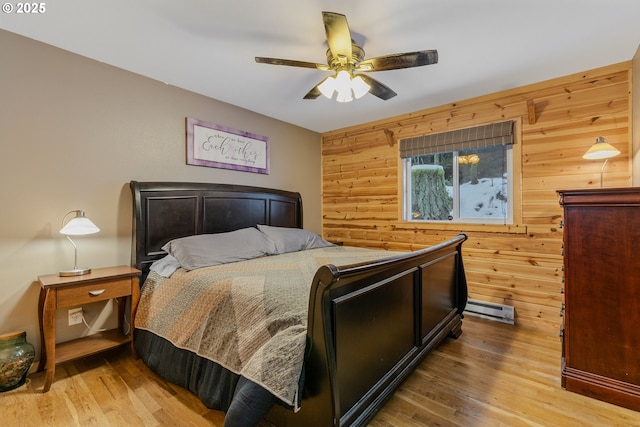 10256 Ridgeview Ter, Birkenfeld, OR 97016 - bedroom with wooden walls, wood finished floors, a baseboard heating unit, and a ceiling fan