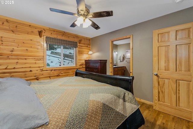 10256 Ridgeview Ter, Birkenfeld, OR 97016 - bedroom featuring wood finished floors, wooden walls, ensuite bath, a ceiling fan, and baseboards