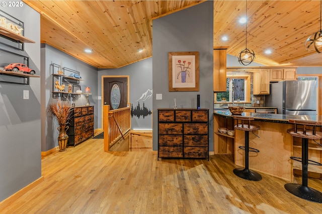 10256 Ridgeview Ter, Birkenfeld, OR 97016 - kitchen with freestanding refrigerator, wooden ceiling, light wood-style floors, dark countertops, and a kitchen bar