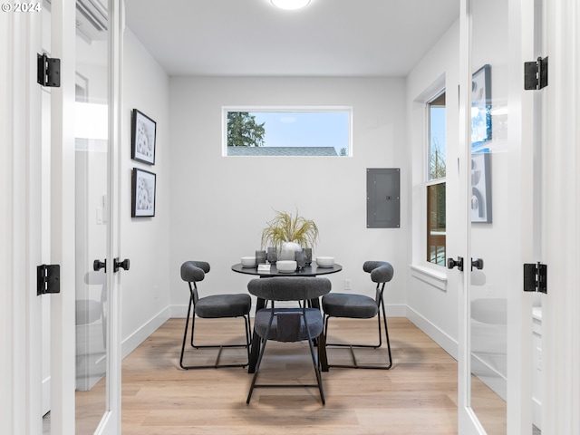 dining area featuring light hardwood / wood-style flooring, electric panel, and french doors