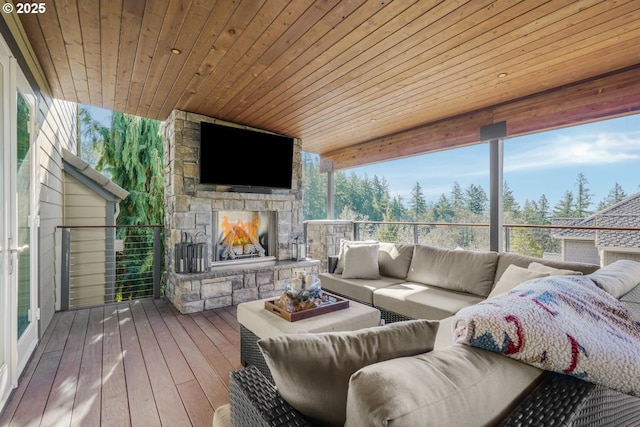 sunroom / solarium featuring wood ceiling and an outdoor stone fireplace