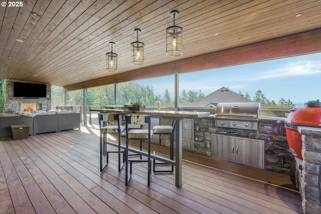 deck with area for grilling, an outdoor kitchen, and an outdoor living space with a fireplace