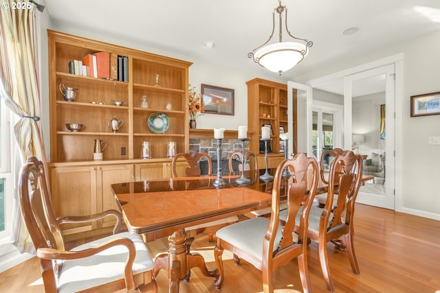 dining area featuring light wood-type flooring and baseboards