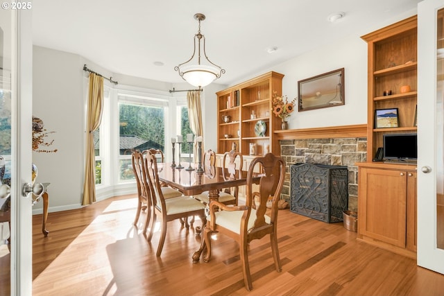 dining space with light wood-type flooring and a fireplace