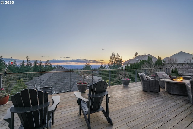 deck at dusk featuring a fire pit