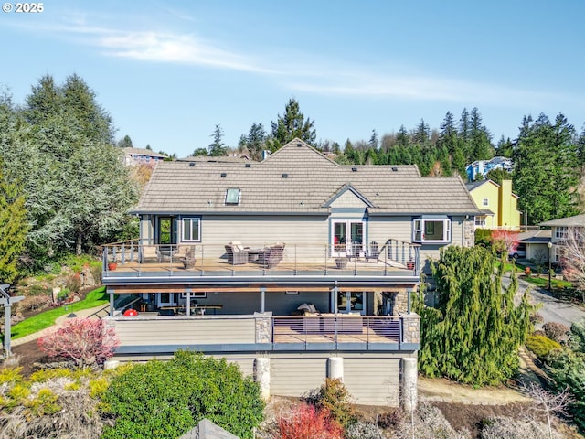 back of house featuring a balcony, french doors, and a tiled roof