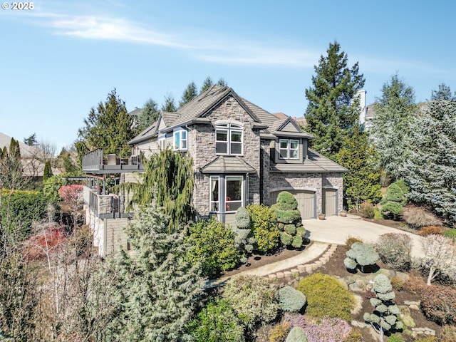 view of front of property featuring a garage, stone siding, and concrete driveway