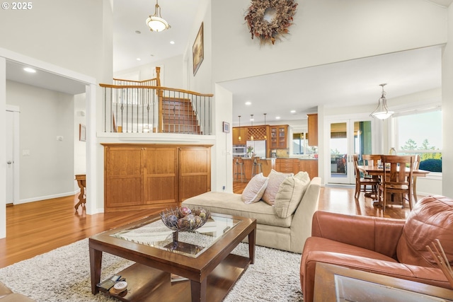 living area featuring a high ceiling, wood finished floors, and recessed lighting