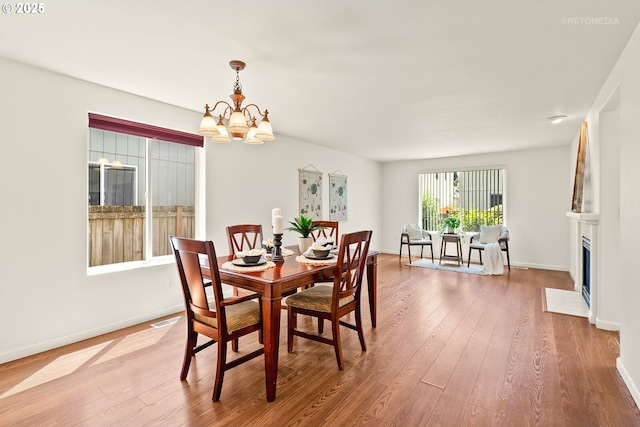 4744 SE Maxwell St, Hillsboro, OR 97123 - dining space with a chandelier, hardwood / wood-style flooring, baseboards, and a fireplace with flush hearth