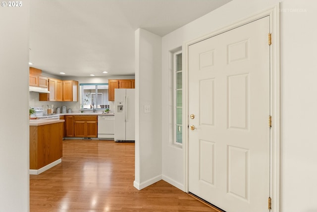 4744 SE Maxwell St, Hillsboro, OR 97123 - kitchen with white appliances, light countertops, under cabinet range hood, light wood finished floors, and baseboards