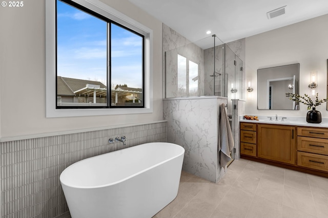 17716 NE 25th Ct, Ridgefield, WA 98642 - bathroom with tile walls, a marble finish shower, a freestanding tub, vanity, and tile patterned floors