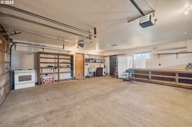 8095 Bewley St, Bay City, OR 97107 - garage with a garage door opener, freestanding refrigerator, and a sink