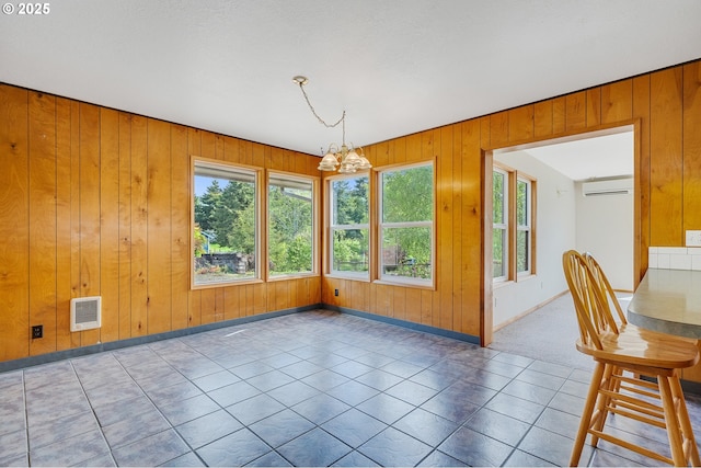 8095 Bewley St, Bay City, OR 97107 - unfurnished dining area with a chandelier, heating unit, a wall mounted air conditioner, wood walls, and baseboards