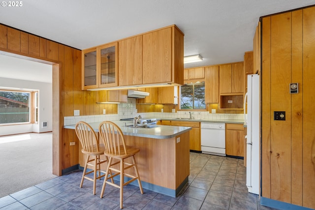 8095 Bewley St, Bay City, OR 97107 - kitchen featuring white appliances, a peninsula, a sink, backsplash, and glass insert cabinets